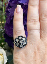 Load image into Gallery viewer, A sapphire and diamond flower cluster ring displayed on a finger
